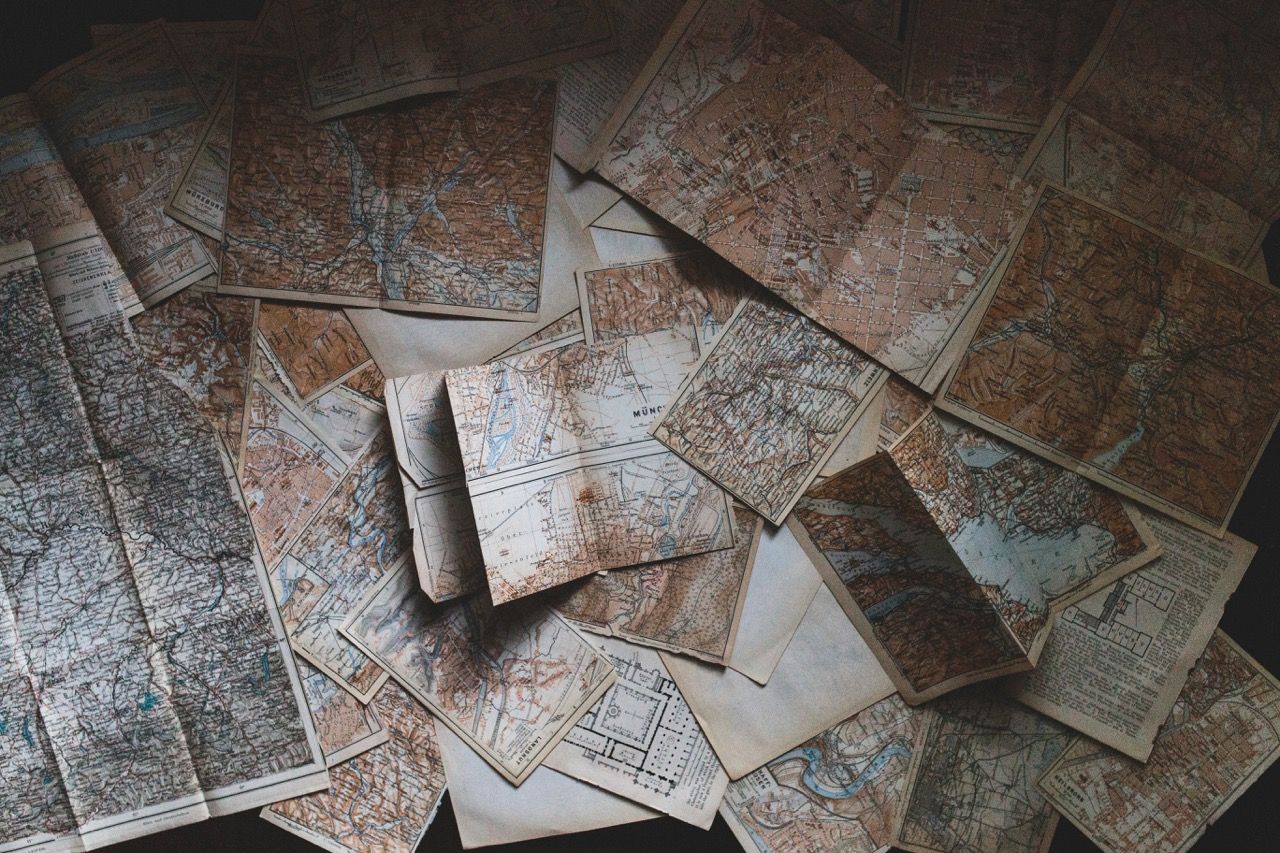 Scattered vintage maps for an urban treasure hunt team activity