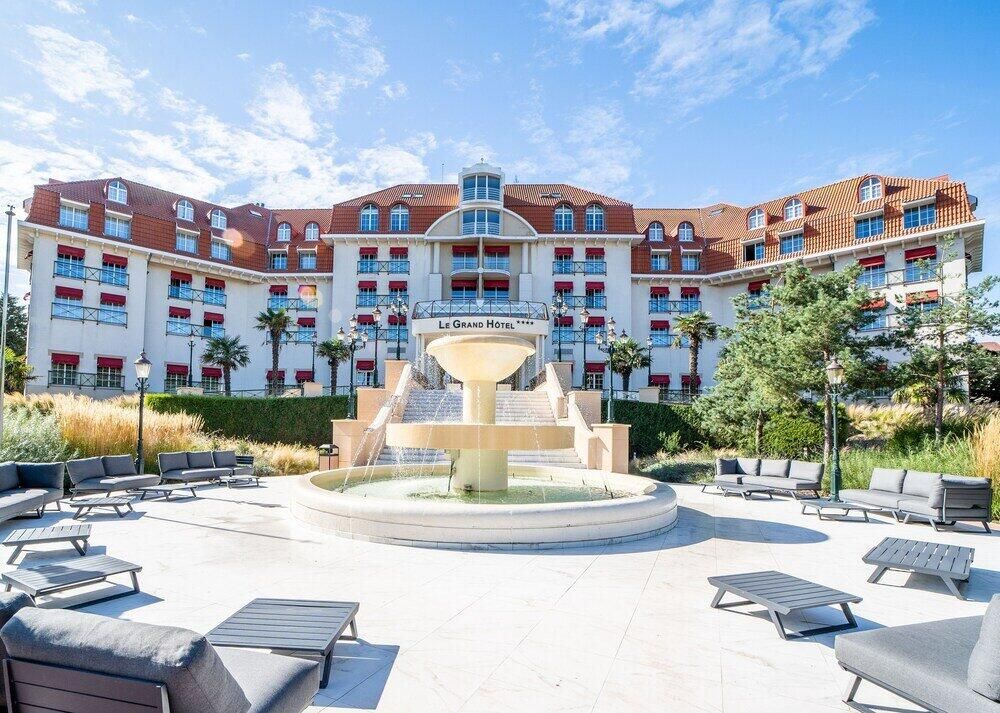 Le Grand Hotel, an elegant corporate event venue with a grand fountain and outdoor lounge space.