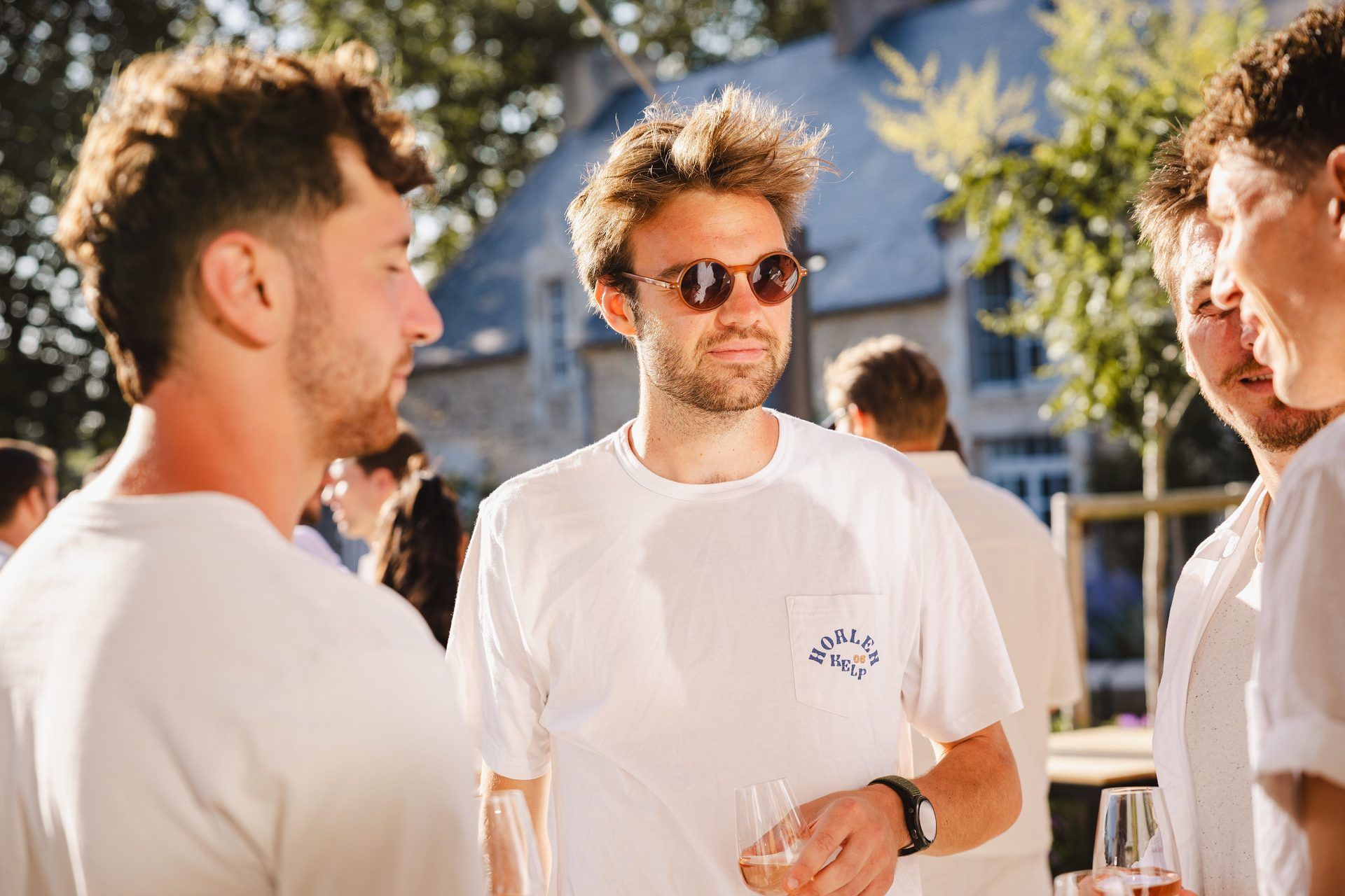 Mannen genieten van een zonnige buitenborrel op een historische evenementenlocatie.