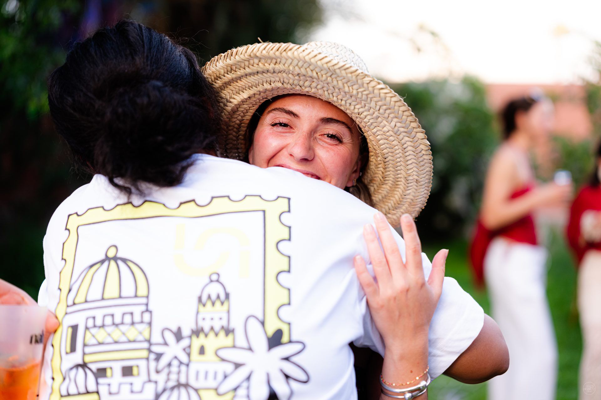 Two Naboo colleagues hugging at the 2026 Marrakech offsite, the illustrated Marrakesh T-shirt print on the back