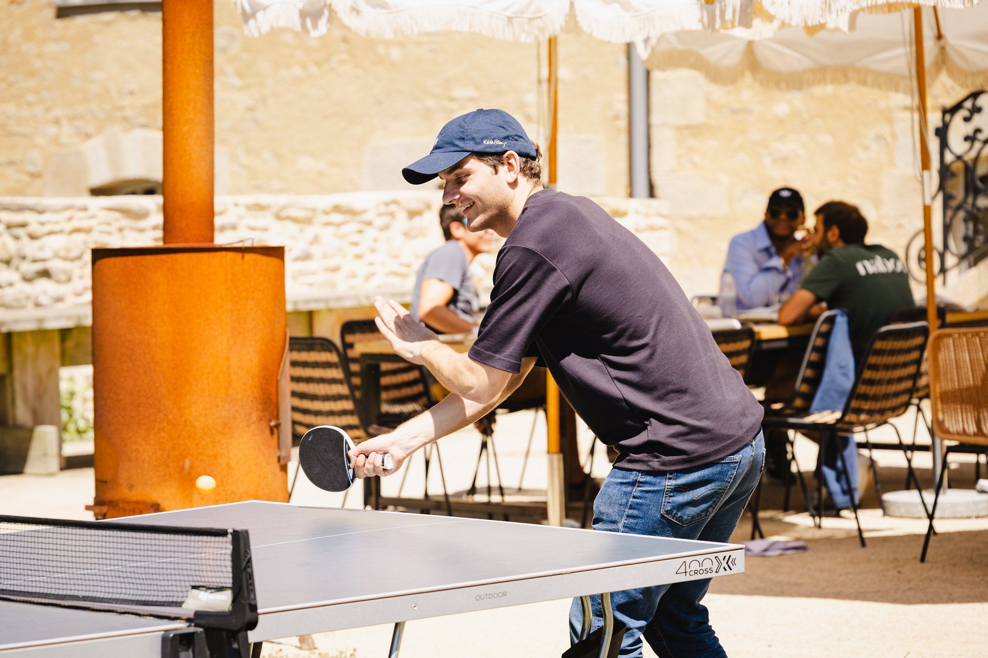 Naboo colleague playing ping-pong on the lawn next to the outdoor lunch tables at the Naboo team seminar, July 2025