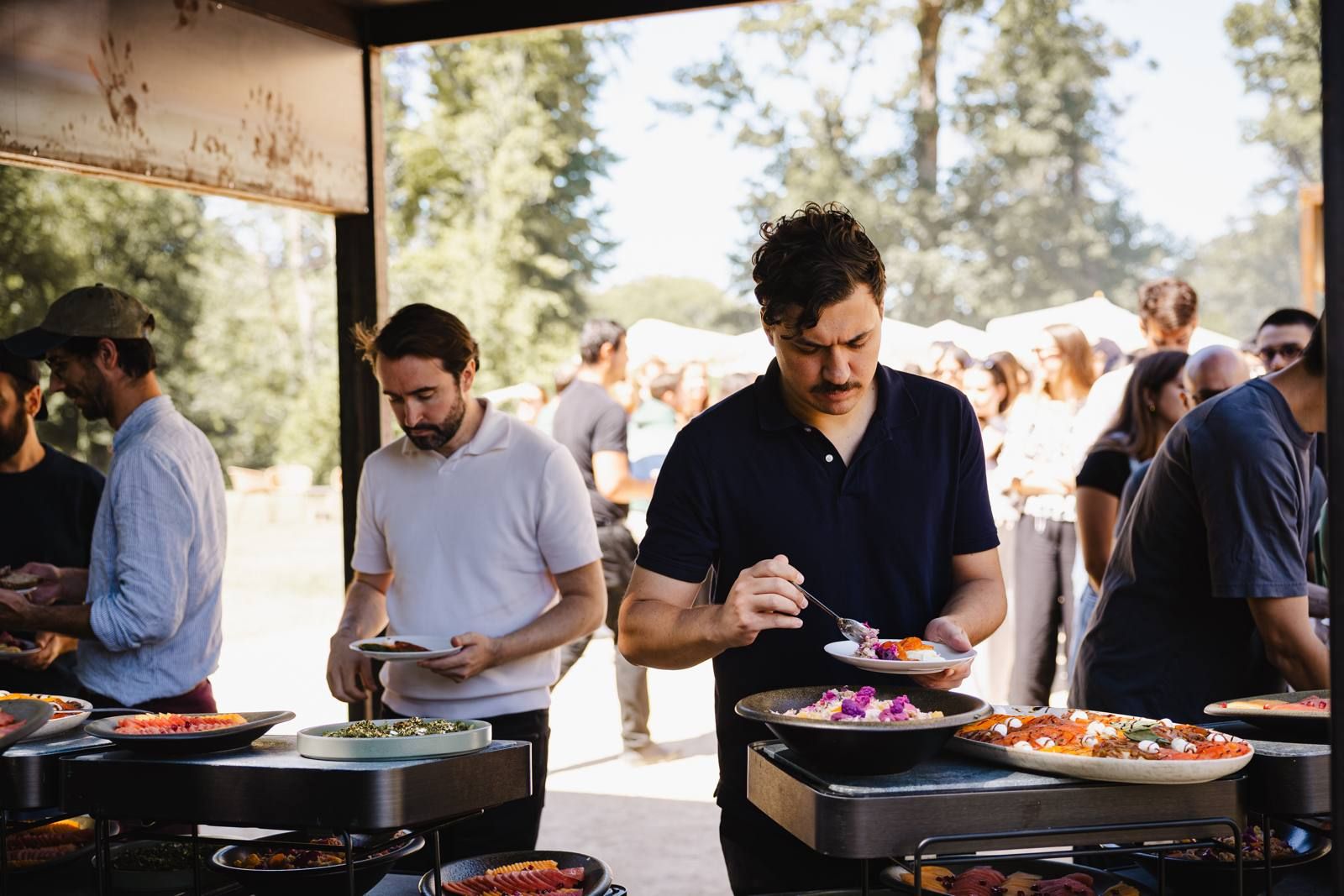 Colleagues serving themselves at an outdoor buffet and grill station during the Naboo July 2025 company seminar